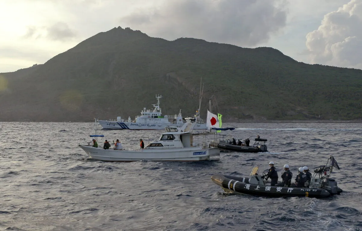 Japanese Coast Guard vessel and boats (rear and right) sail alongside a Japanese activists' fishing boat (center) near a group of disputed islands called Diaoyu by China and Senkaku by Japan on Aug. 18, 2013. (Emily Wang/AP Photo)