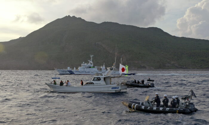 Japanese Coast Guard vessel and boats (rear and right) sail alongside a Japanese activists' fishing boat (center) near a group of disputed islands called Diaoyu by China and Senkaku by Japan on Aug. 18, 2013. (Emily Wang/AP Photo)