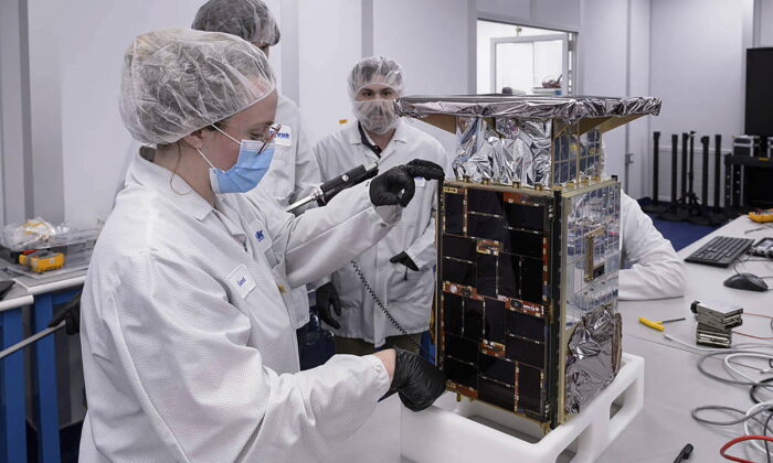 Rebecca Rogers, systems engineer (L), takes dimension measurements of the Capstone spacecraft at Tyvak Nano-Satellite Systems, Inc. in Irvine, Calif., on April 2022. (Dominic Hart/NASA via AP)