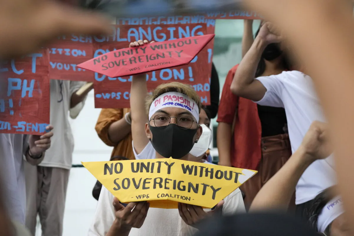 Protesters hold slogans to mark the 6th anniversary of the 2016 international ruling that declared China's claims in the South China Sea illegal during a rally outside the Chinese consulate in Makati, Philippines on July 12, 2022. (AP Photo/Aaron Favila)