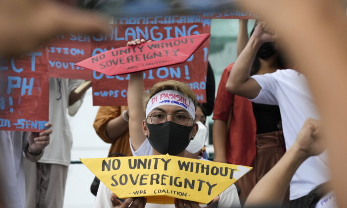 Protesters hold slogans to mark the 6th anniversary of the 2016 international ruling that declared China's claims in the South China Sea illegal during a rally outside the Chinese consulate in Makati, Philippines on July 12, 2022. (AP Photo/Aaron Favila)