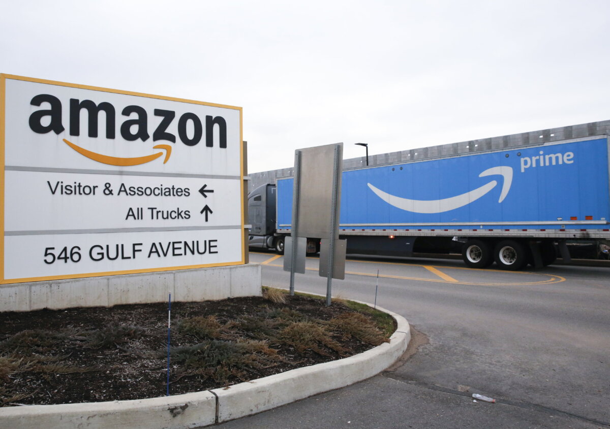 An Amazon Prime truck passes by a sign outside an Amazon fulfillment center on Staten Island, New York, on March 19, 2020. (Kathy Willens/AP Photo)