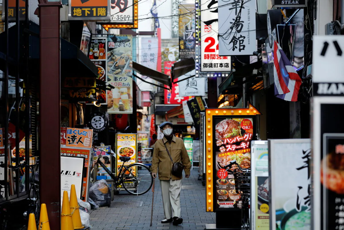 A man wearing a protective mask, amid the coronavirus disease (COVID-19) outbreak, makes his way at a restaurant district in Tokyo on Dec. 1, 2021. (Kim Kyung-Hoon/Reuters)