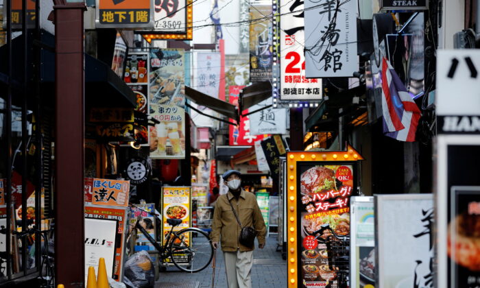 A man wearing a protective mask, amid the coronavirus disease (COVID-19) outbreak, makes his way at a restaurant district in Tokyo on December 1, 2021. (Kim Kyung-Hoon/Reuters)