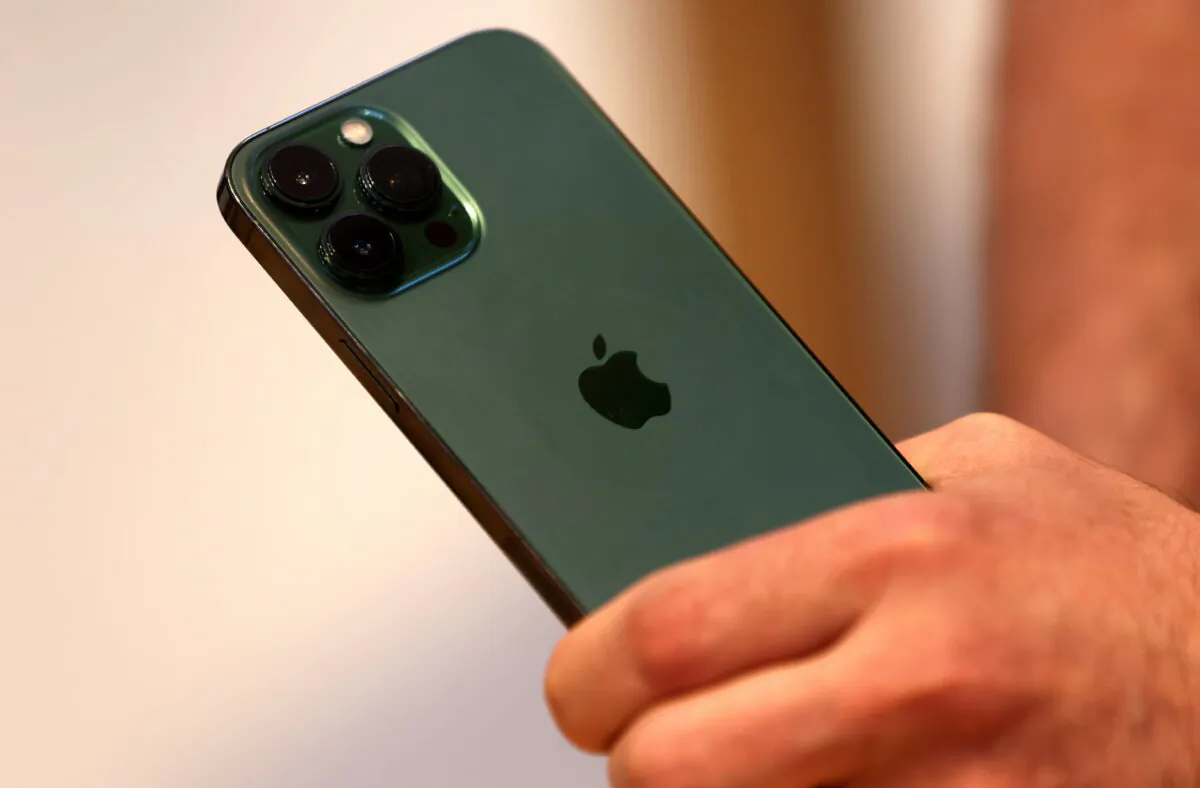 A customer holds the new green colour Apple iPhone 13 pro shortly after it went on sale inside the Apple Store on 5th Avenue in Manhattan in New York on March 18, 2022. (Mike Segar/Reuters)