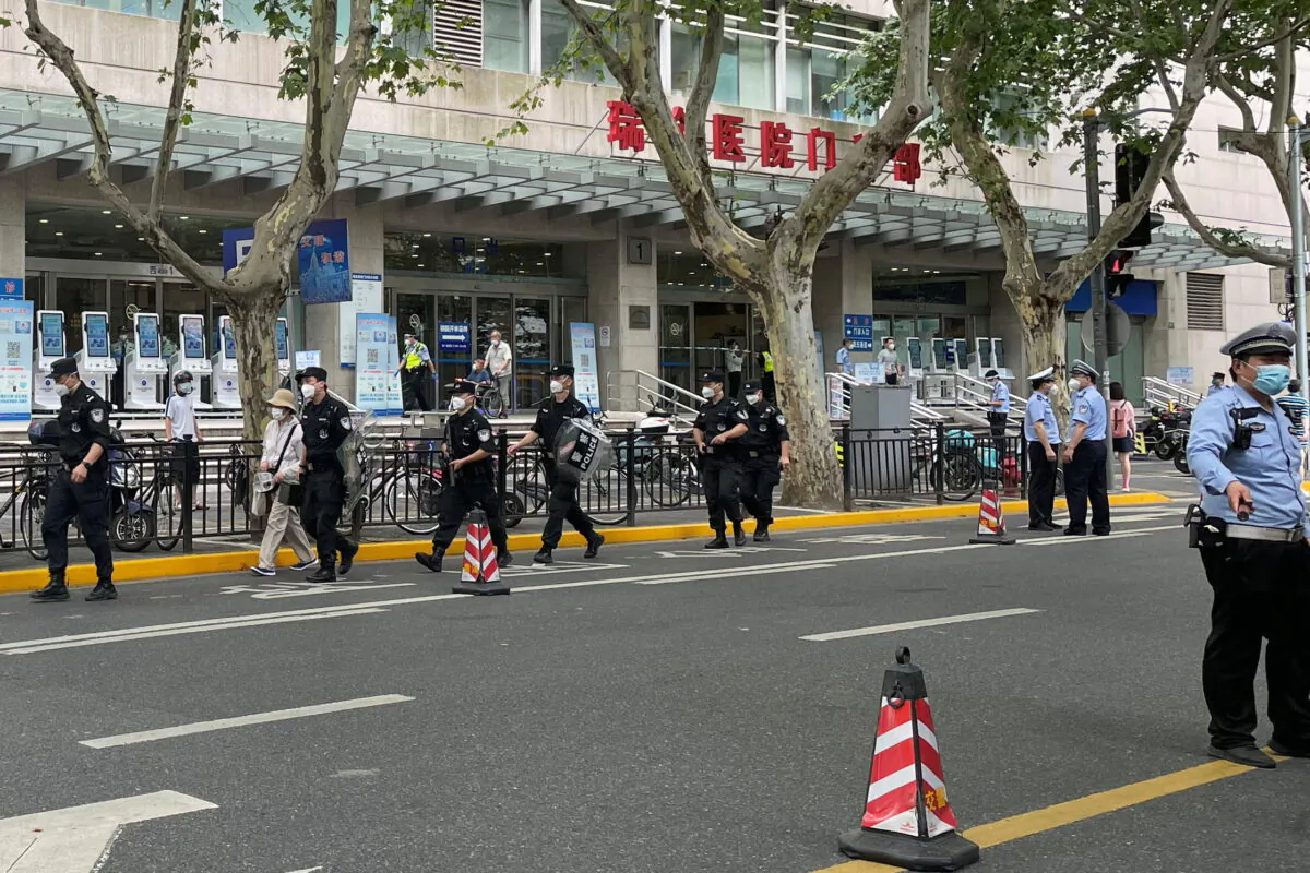Police officers walk outside the outpatient department of Ruijin Hospital following a stabbing incident in Shanghai on July 9, 2022. (Brenda Goh/Reuters)