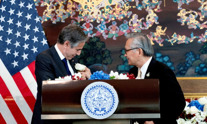 Thailand's Foreign Minister Don Pramudwinai (R), places a flower on the jacket of U.S. Secretary of State Antony Blinken following remarks to the press after a Memorandum of Understanding signing ceremony at the Thai Ministry of Foreign Affairs in Bangkok, Thailand,  July 10, 2022. Stefani Reynolds/Pool via REUTERS