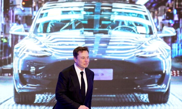 2020 年 1 月 7 日，特斯拉中国制造的 Model Y 计划在上海举行的开幕式上，特斯拉首席执行官埃隆·马斯克 (Elon Musk) 走在显示特斯拉 Model 3 汽车图像的屏幕旁边。（Aly Song/路透社）