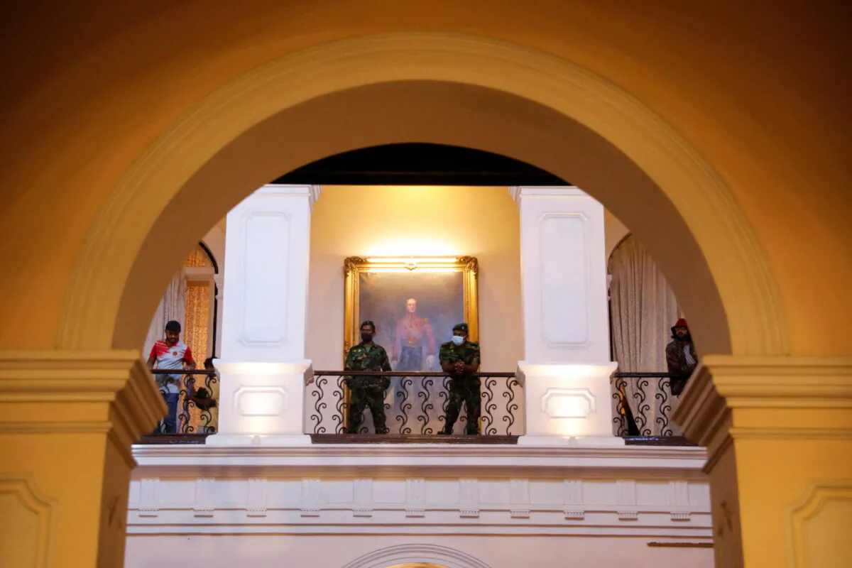 Security personnel stand as people visit the president's house after President Gotabaya Rajapaksa fled, amid the country's economic crisis, in Colombo, Sri Lanka, on July 13, 2022. (Adnan Abidi/Reuters)