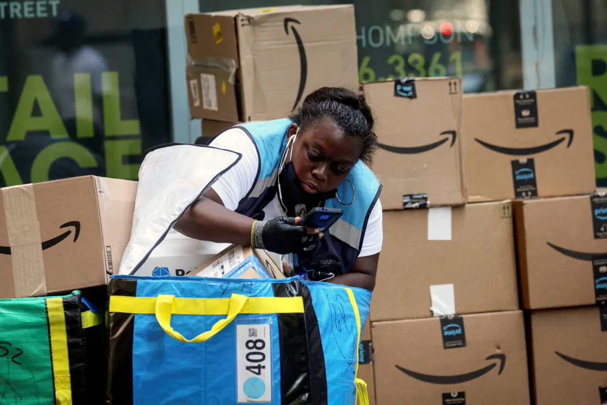 An Amazon delivery worker checks packages in New York City on July 11, 2022. (Brendan McDermid/Reuters)