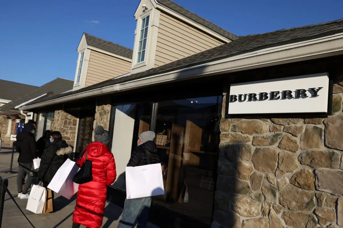 People stand outside Burberry at the Woodbury Common Premium Outlets in Central Valley, N.Y., on Feb. 15, 2022. (Andrew Kelly/Reuters)