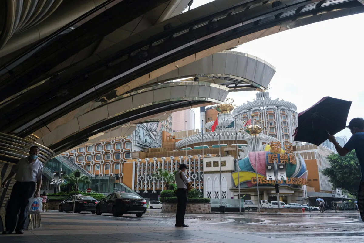 People stand near Casino Lisboa amid the COVID-19 outbreak in Macao on July 4, 2022. (John Mak/Reuters)