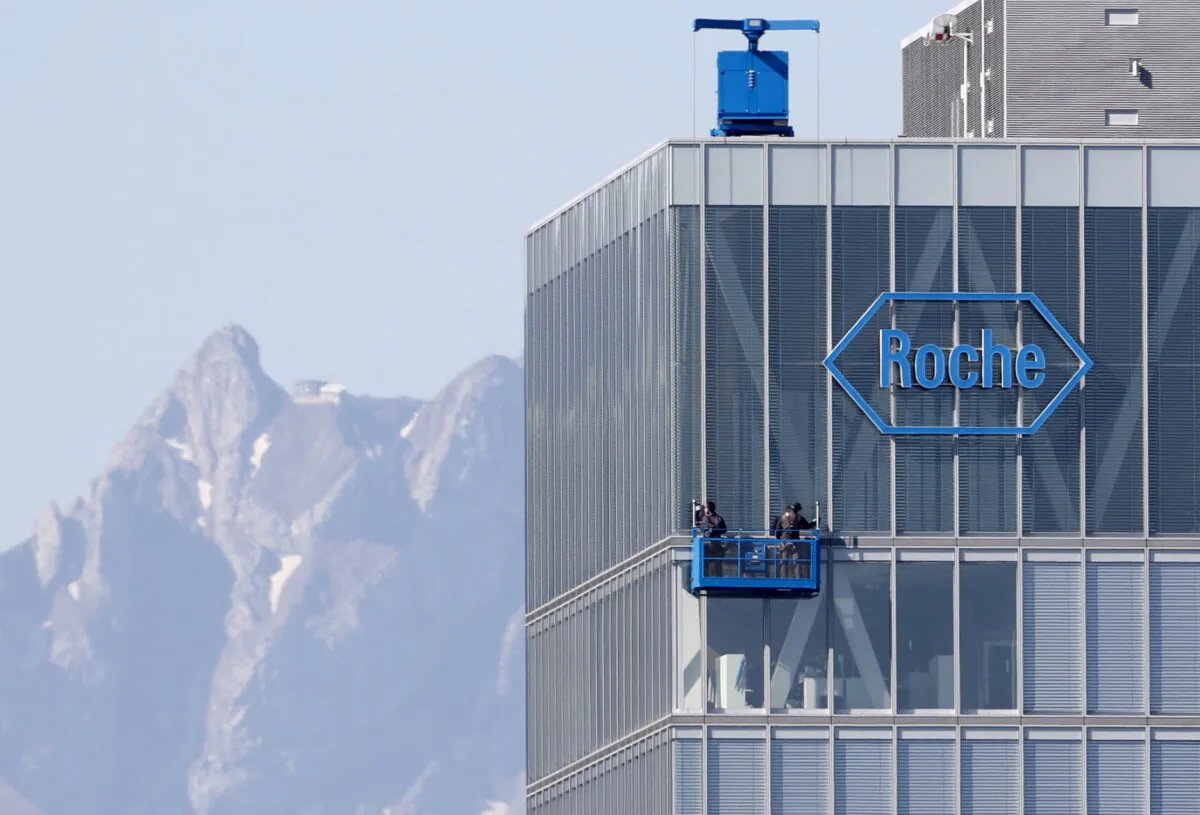 The peak of Mount Pilatus in the background as workers clean the windows of a building of Roche in Rotkreuz on May 27, 2020. (Arnd Wiegmann/Reuters)