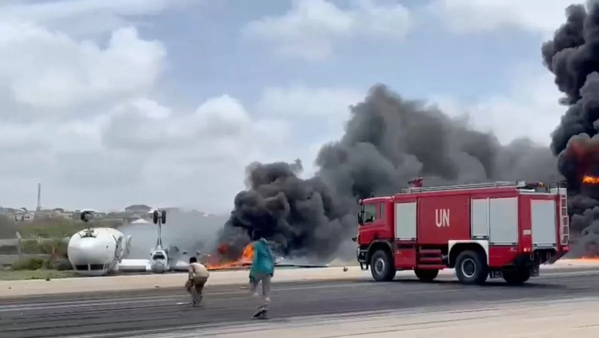 Smoke billows from a plane that flipped over after a crash landing in Mogadishu, Somalia, on July 18, 2022, in this screen grab obtained from a social media video. (Reuters)