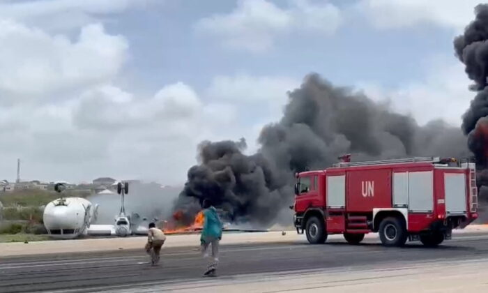 Smoke billows from a plane that flipped over after a crash landing in Mogadishu, Somalia, on July 18, 2022, in this screen grab obtained from a social media video. (Reuters)