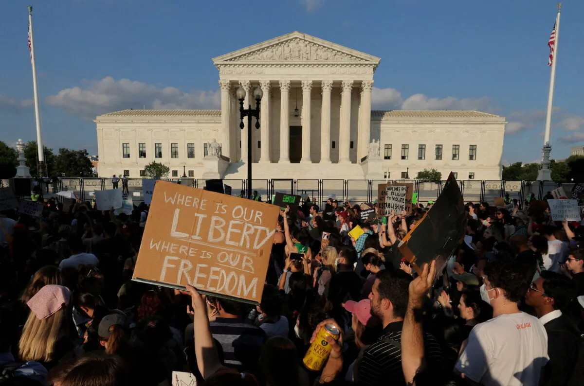 Pro-abortion protesters stand outside the U.S. Supreme Court as the court deliberates overturning Roe v. Wade in Washington on June 24, 2022. (Jim Bourg/Reuters)