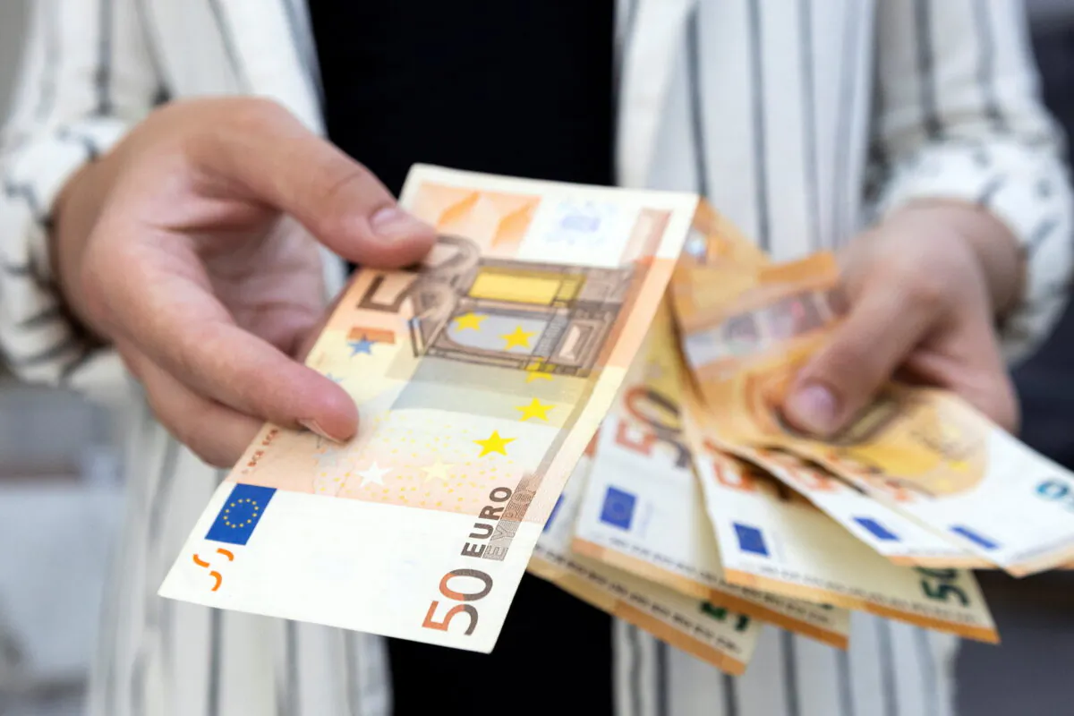A woman holds euro banknotes in this illustration taken on May 30, 2022. (Reuters/Dado Ruvic)