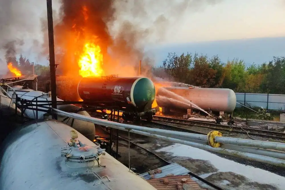 Firefighters gather near tank cars as they work to extinguish a fire at an oil depot in the Budyonnovsky district of Donetsk, Ukraine on July 26, 2022. (Press Service of Emergencies Ministry of Donetsk People's Republic/Handout via Reuters)