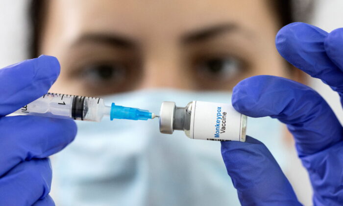 A woman holds a mock-up vial labeled "Monkeypox vaccine" and medical syringe in this illustration taken on May 25, 2022. (Dado Ruvic/Illustration/Reuters)