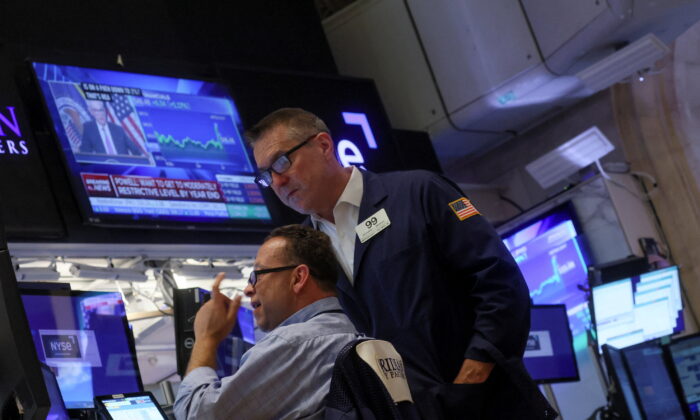 Traders react on the floor of the New York Stock Exchange (NYSE) as a screen shows Federal Reserve Board Chairman Jerome Powell during a news conference following a Fed rate announcement, in New York City on July 27, 2022. (Brendan McDermid/Reuters)