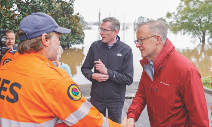 Australian Prime Minister Anthony Albanese (R) shakes hands with State Emergency Service workers on a tour of flood-affected areas with New South Wales Premier Dominic Perrottet in the suburb of Richmond in Sydney, Australia, on July 6, 2022. (Jenny Evans/Getty Images)