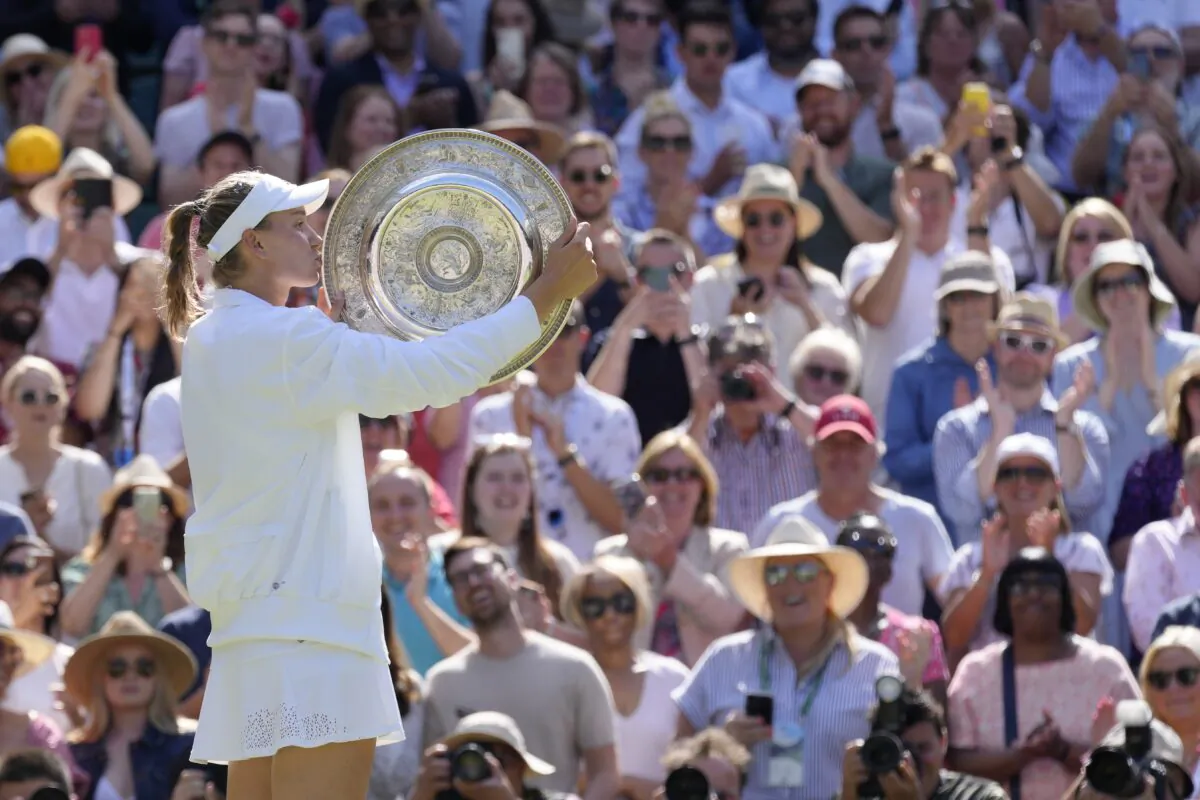 Kazakhstan's Elena Rybakina kisses the trophy as she celebrates after beating Tunisia's Ons Jabeur to win the final of the women's singles on day thirteen of the Wimbledon tennis championships in London, on July 9, 2022. (Kirsty Wigglesworth/AP Photo/)