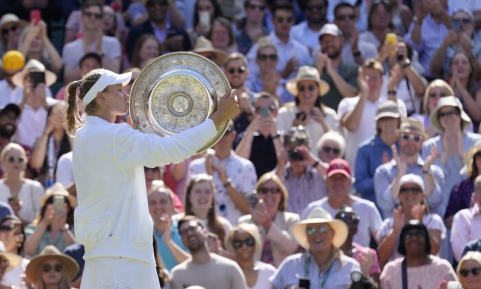 Kazakhstan's Elena Rybakina kisses the trophy as she celebrates after beating Tunisia's Ons Jabeur to win the final of the women's singles on day thirteen of the Wimbledon tennis championships in London, on July 9, 2022. (Kirsty Wigglesworth/AP Photo/)