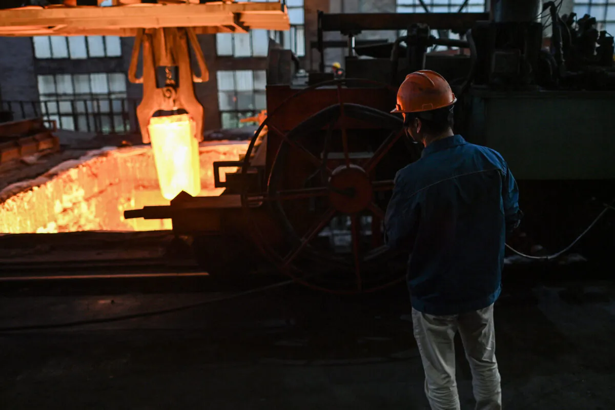 A worker operates a crane to transport a block of steel into an oven during a government organised tour at a Tiangong International plant, makers of high quality steel and tools, in Zhenjiang in China's eastern Jiangsu province on Oct. 12, 2020. (Hector Retamal / AFP via Getty Images)