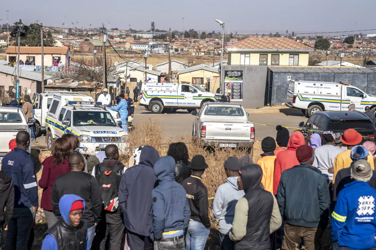 People gather at the scene of an overnight bar shooting in Soweto, South Africa, on July 10, 2022. (Shiraaz Mohamed/AP Photo)