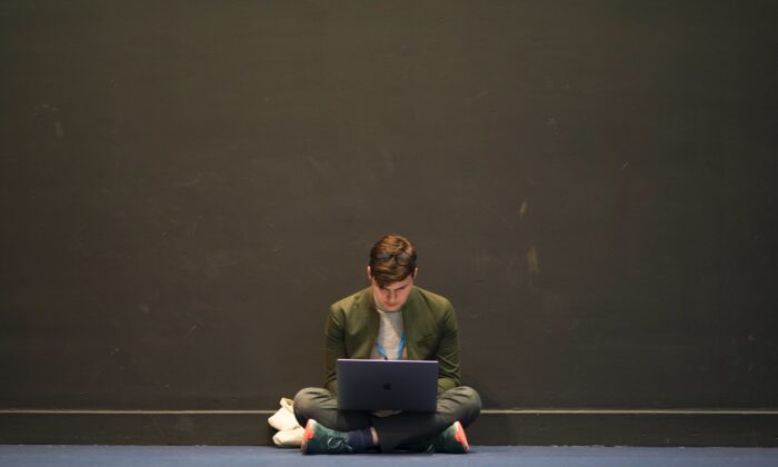 A delegate works on his laptop on the third day of the Conservative Party Conference at Manchester Central Convention Complex in Manchester, England, on Oct. 5, 2021. (Ian Forsyth/Getty Images)