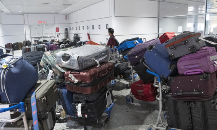 A passenger looks for his luggage among a pile of unclaimed baggage at Pierre Elliott Trudeau airport in Montreal on June 29, 2022. (Ryan Remiorz/The Canadian Press)