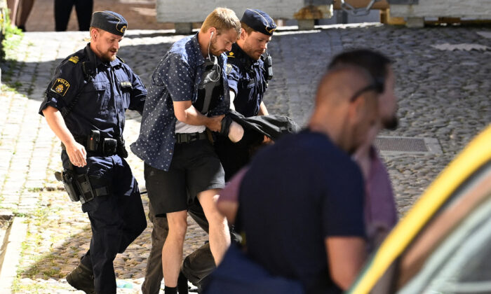 Police arrest a man (C hidden) suspected of seriously injuring by stabbing a woman at the Almedalen political festival in Visby on the Swedish island of Gotland on July 6, 2022. (Henrik Montgomery/TT News Agency/AFP via Getty Images)