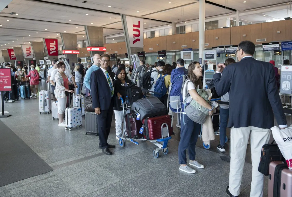 Passengers lineup at the check in counter at Pierre Elliott Trudeau airport, in Montreal, June 29, 2022. (The Canadian Press/Ryan Remiorz)