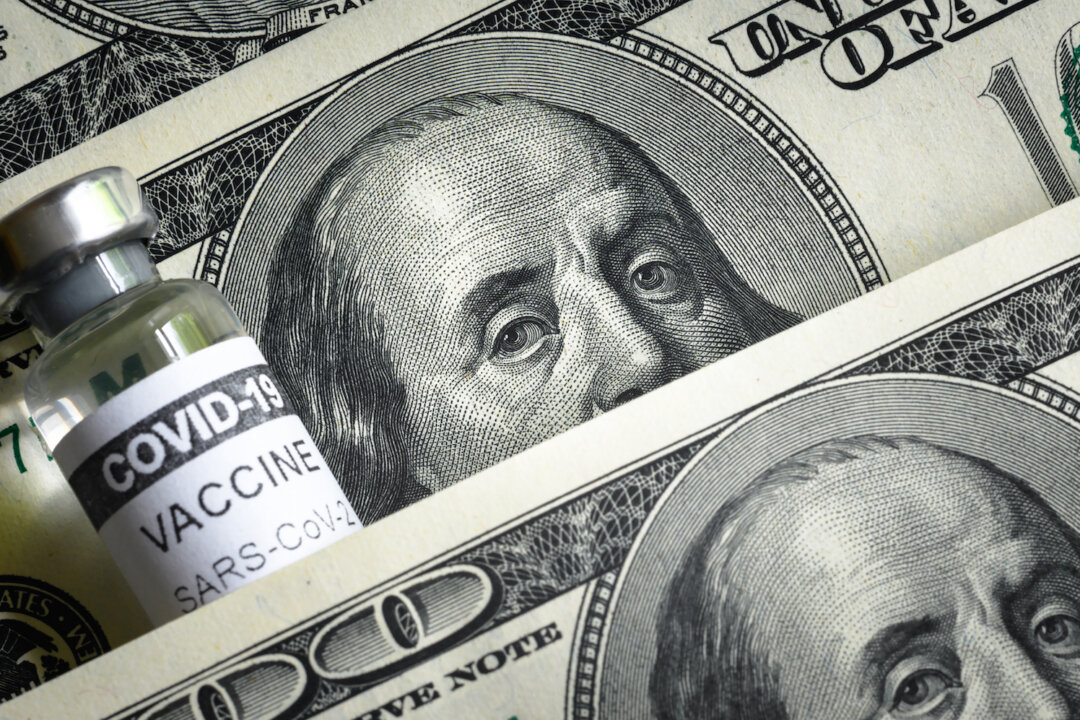 A COVID vaccine vial and $100 bills. (Viacheslav Lopatin/Shutterstock)