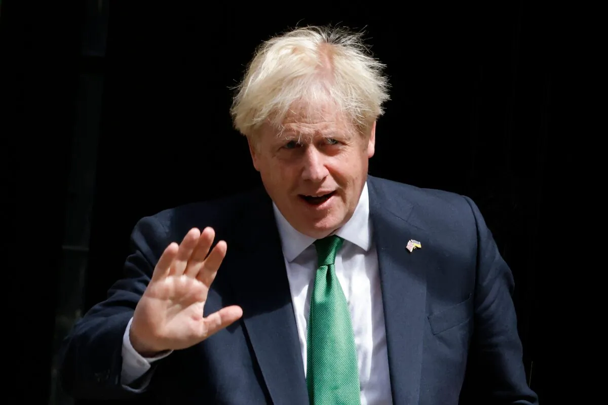 Britain's Prime Minister Boris Johnson waves while walking to a waiting car as he leaves from 10 Downing Street to head to the Houses of Parliament for the weekly Prime Minister's Questions, in central London, on July 13, 2022. (Carlos Jasso/AFP via Getty Images)