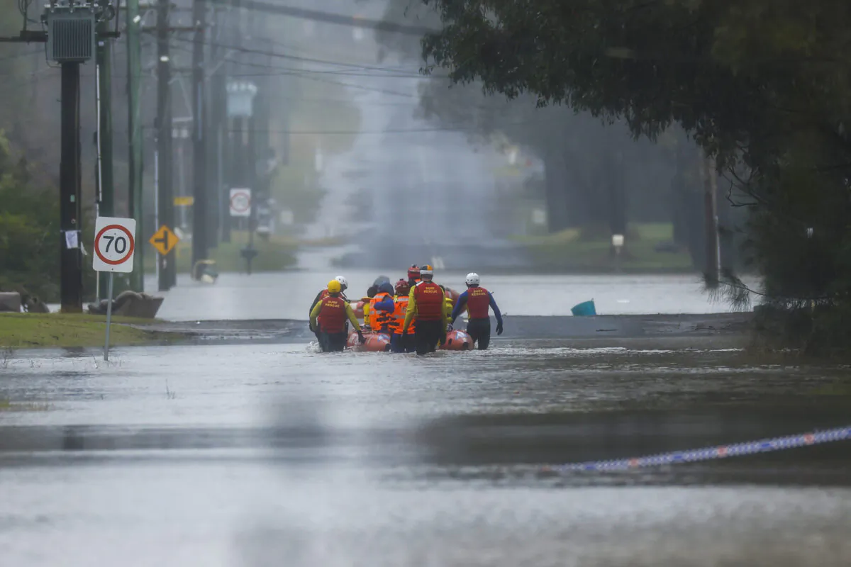 A family are evacuated by State Emergency Service workers due to rising floodwaters in Sydney, Australia, on July 4, 2022. (Jenny Evans/Getty Images)