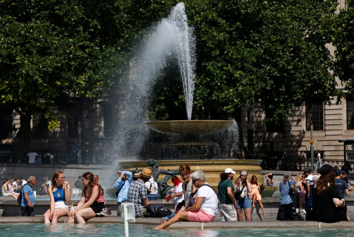 People cool off beside the fountains in Trafalgar Square in central London on June 17, 2022. (Carlos Jasso/AFP via Getty Images)