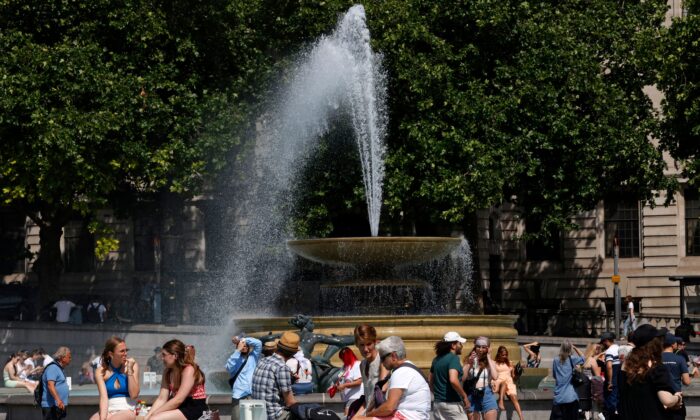 People cool off beside the fountains in Trafalgar Square in central London on June 17, 2022. (Carlos Jasso/AFP via Getty Images)