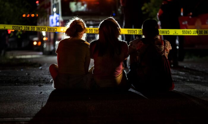 Family and friends watch as Indianapolis Metropolitan Police Department investigators search for a father and three children on Bluff Road in Ind., on July 12, 2022. (Grace Hollars/The Indianapolis Star via AP)