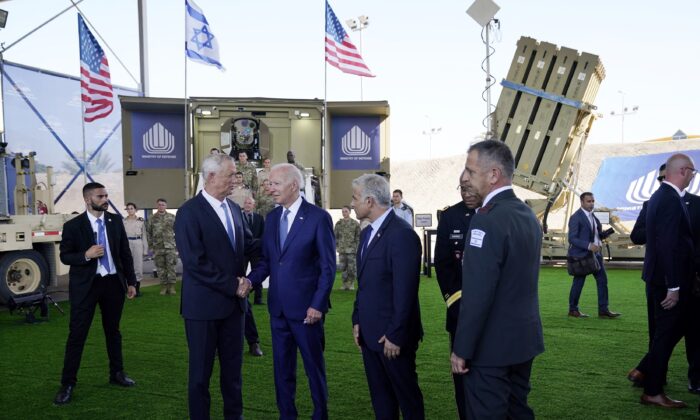 President Joe Biden shakes hands with Israeli Defense Minister Benny Gantz, as he is shown views of aerial defense systems as Israeli Prime Minister Yair Lapid, right of Biden, looks on, in Tel Aviv, Israel, on July 13, 2022. (Evan Vucci/AP Photo)