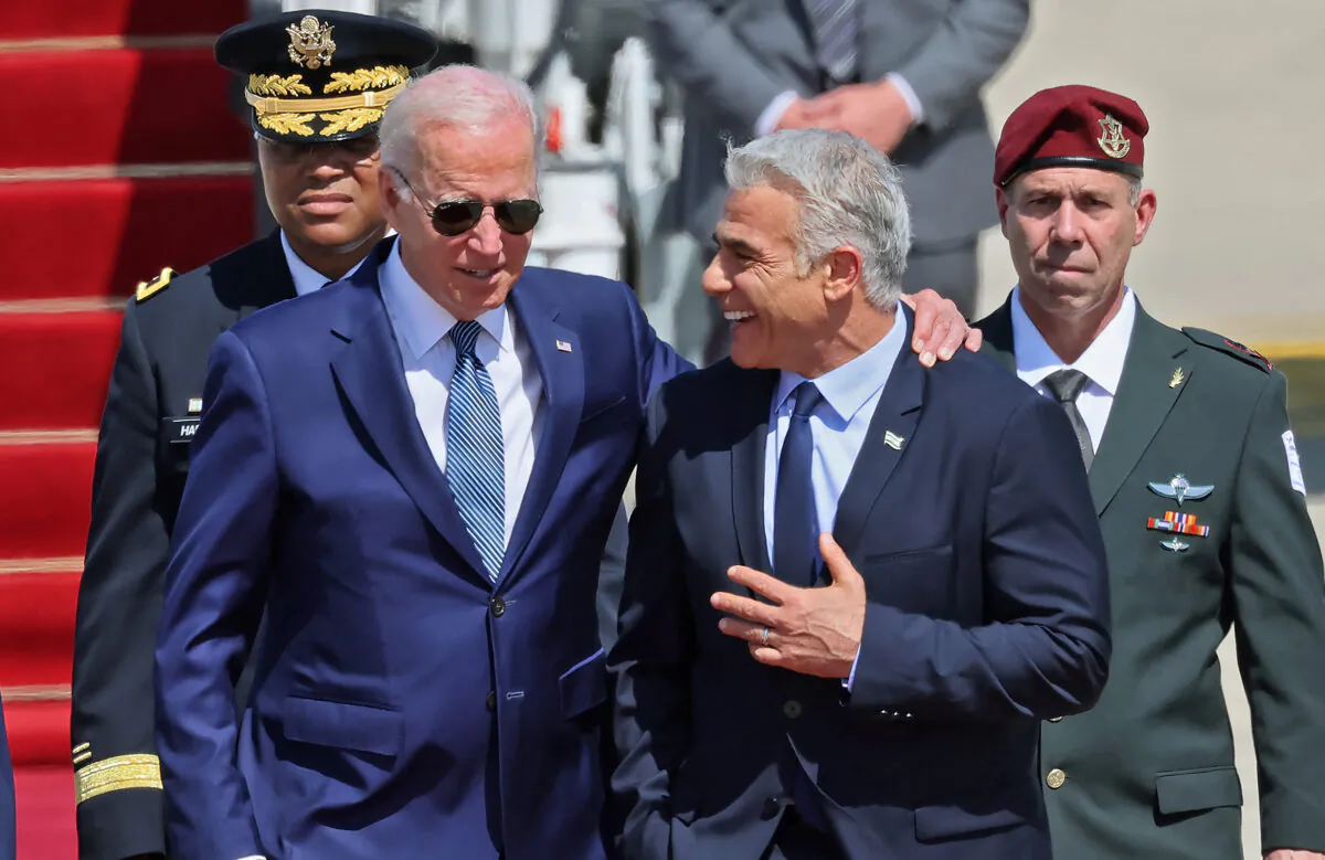 President Joe Biden (L) is welcomed by Israeli caretaker Prime Minister Yair Lapid after arriving at Israel's Ben Gurion Airport in Lod near Tel Aviv, on July 13, 2022. (Jack Guez/AFP via Getty Images)