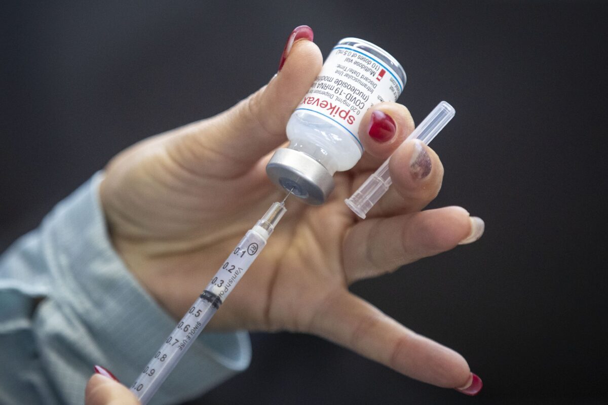 A person draws out Moderna vaccine during a drive through COVID-19 vaccine clinic at St. Lawrence College in Kingston, Ontario, on Jan. 2, 2022. (The Canadian Press/Lars Hagberg)