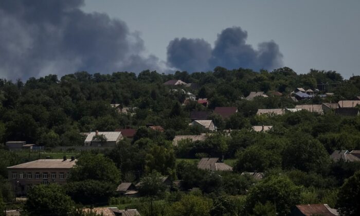 Smoke rises in the sky after strikes at the frontline in the Donbass region on July 13, 2022. (Gleb Garanich/Reuters)