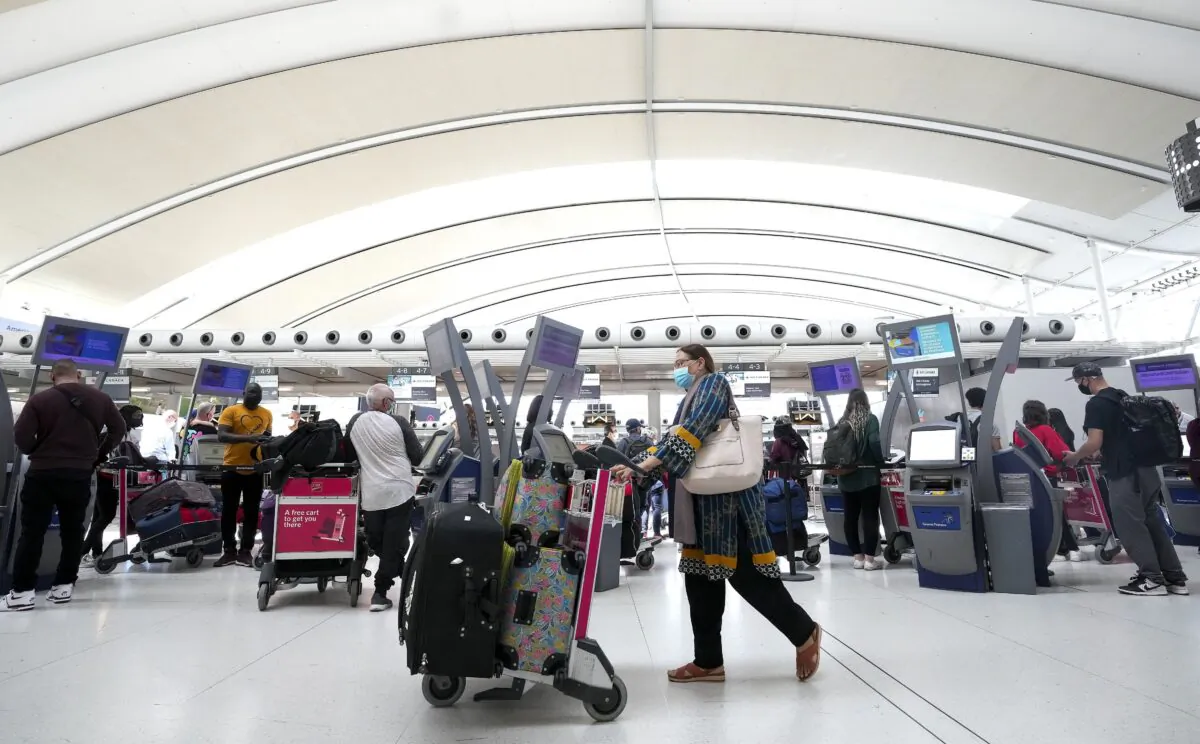 People wait in line to check in at Pearson International Airport in Toronto on May 12, 2022. (Nathan Denette/The Canadian Press)