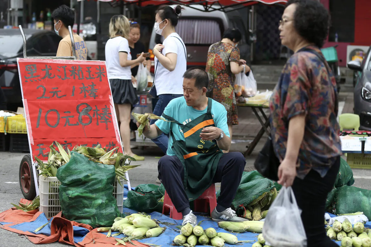 A corn vendor waits for customers at a market in Shenyang, in China's northeastern Liaoning Province, on July 9, 2022. (STR/AFP via Getty Images)