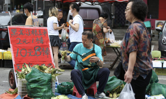 A corn vendor waiting for customers at a market in Shenyang in China's northeastern Liaoning Province, on July 9, 2022. 
(STR/AFP via Getty Images)