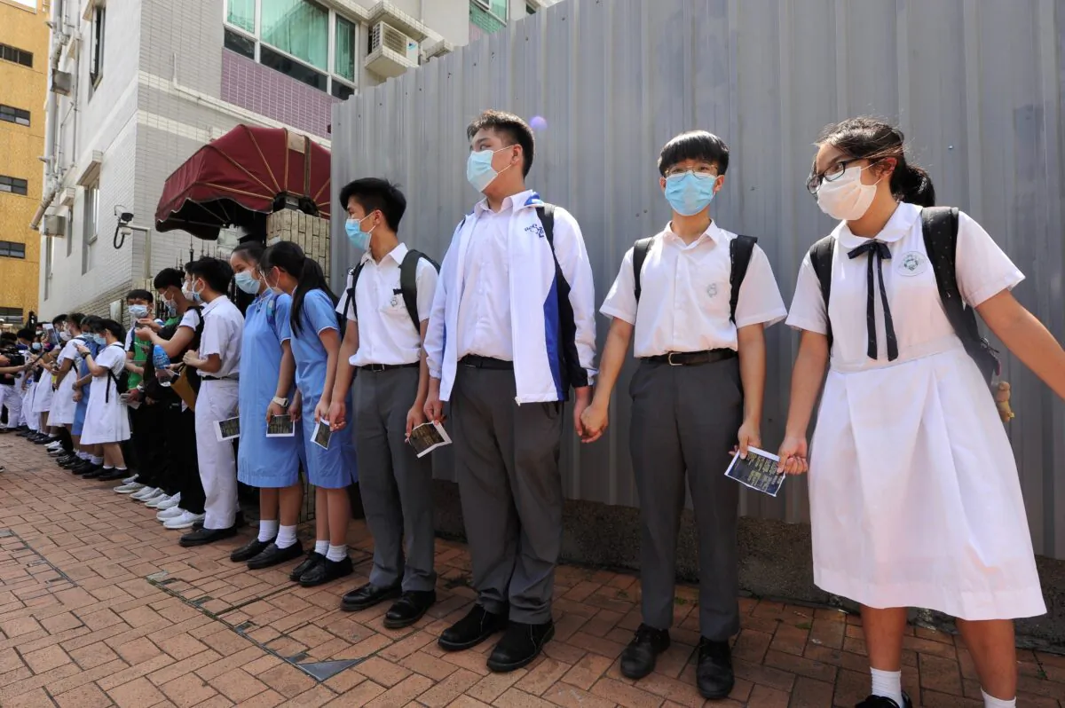 Nearly 100 middle school students set up a chain to protest at the gate of the School to support a female teacher, who was not renewed by the school because she did not stop students from playing "Glory to Hong Kong" during the music examination. June 14, 2020. (Sung Pi-lung/The Epoch Times)