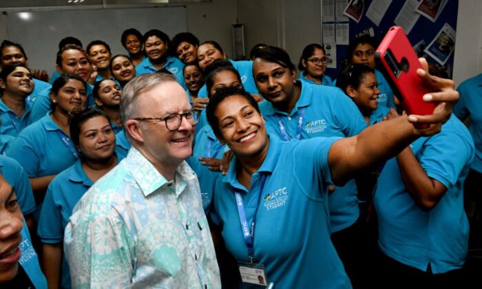 Australian Prime Minister Anthony Albanese (L) poses for a selfie with staff and students during a tour of the Australia Pacific Training Coalition centre (APTC) after attending the Pacific Islands Forum (PIF), in Suva on July 15, 2022. (William West/AFP via Getty Images)