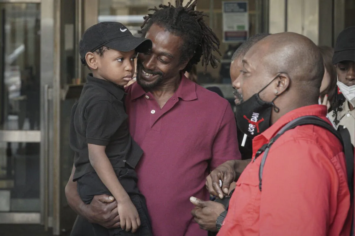 James Irons (C) holds his grand nephew Michael, 5, as he leaves Brooklyn Supreme Court following his exoneration in New York on July 15, 2022. (Bebeto Matthews/AP Photo)