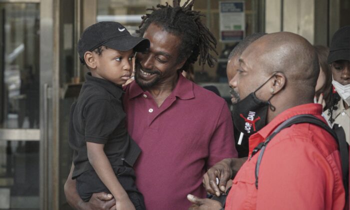 James Irons (C) holds his grand nephew Michael, 5, as he leaves Brooklyn Supreme Court following his exoneration in New York on July 15, 2022. (Bebeto Matthews/AP Photo)